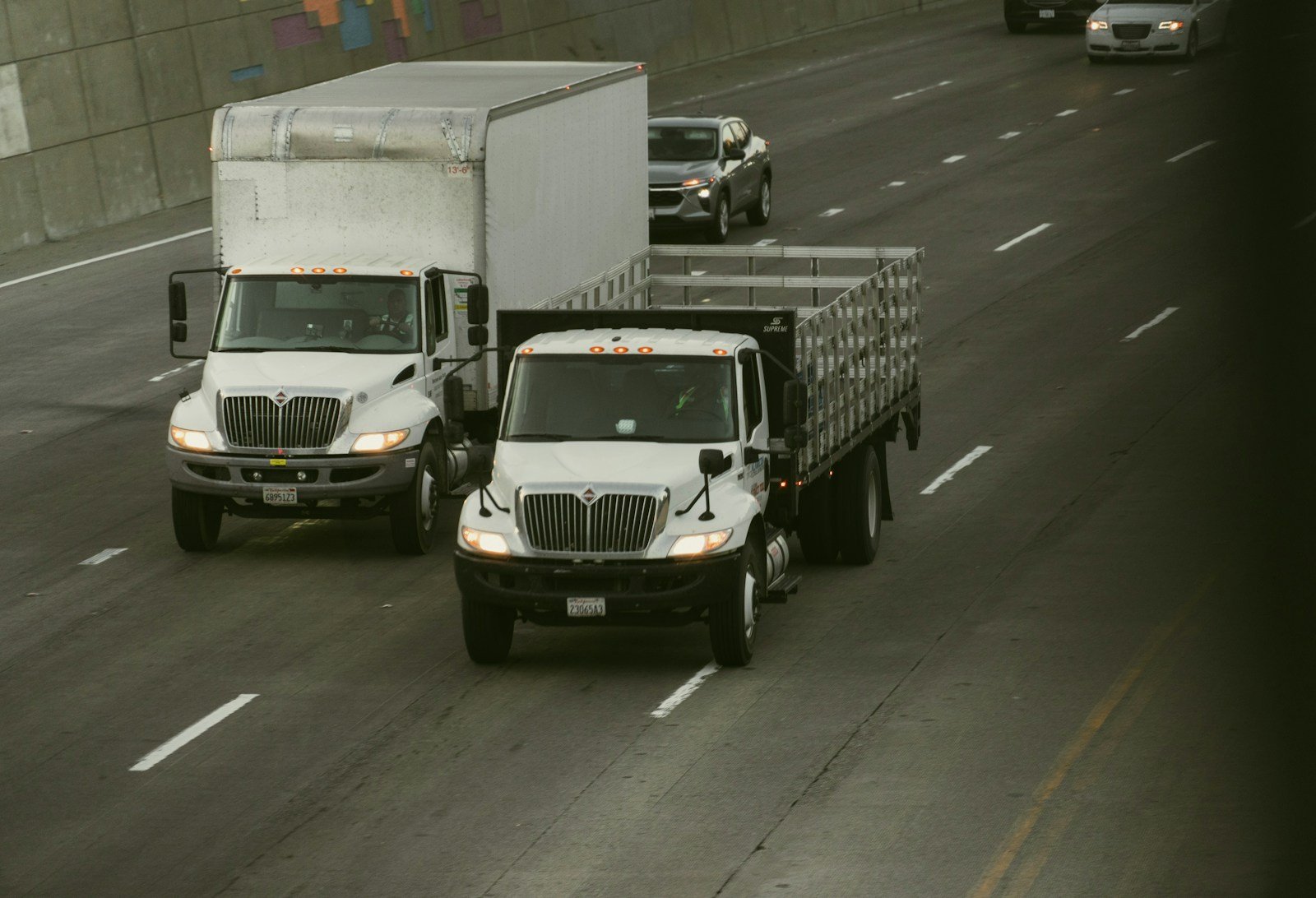 Two freight trucks travelling on a wide highway